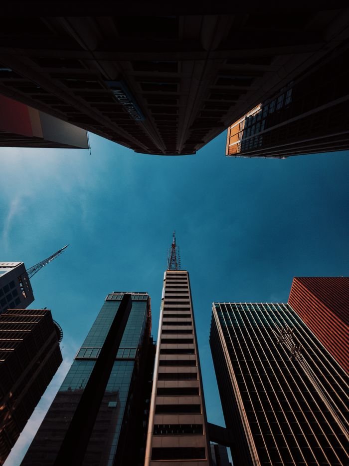 Dramatic upward view of São Paulo’s towering skyscrapers against a clear blue sky.